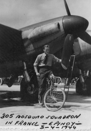 A man stands next to a bicycle and a military aeroplane with "305 Mosquito Squadron in France - Epinoy 3-7-1944" handwritten at the bottom of the photo.