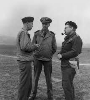 Three military officers in uniform stand outdoors having a discussion; one smokes a pipe. The background is foggy and indistinct.