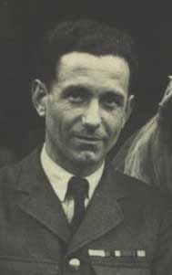 A man in a military uniform with short dark hair looks at the camera. The photo is black and white and cropped closely to his face and upper body.
