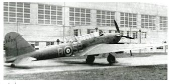 A vintage military aeroplane with a single propeller is parked on the ground in front of a large building with many windows.