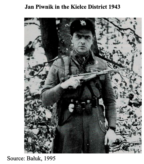 A man in military uniform stands in a wooded area holding a sub-machine gun, identified as Jan Piwnik in the Kielce District in 1943.