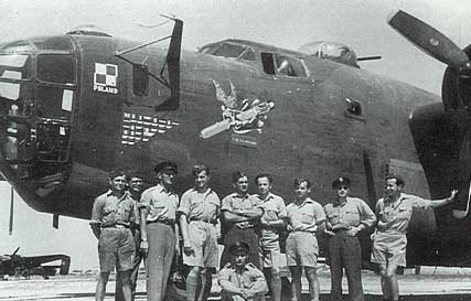 A group of uniformed men stand in front of a Second World War-era military aeroplane with nose art and the word "Poland" on the side.
