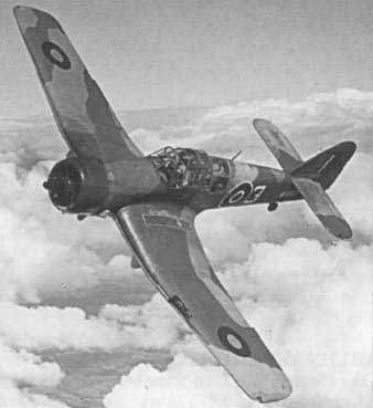 A single-engined, camouflage-painted Second World War military aeroplane with British roundels flies above the clouds.
