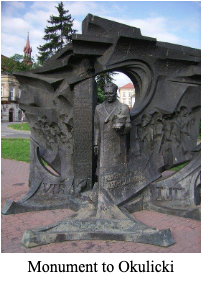 A stone monument featuring a standing figure of General Okulicki in front of a sculpted background with figures in relief.