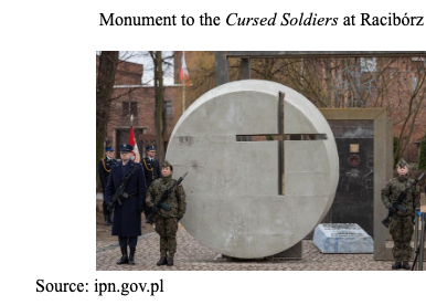 Three soldiers stand guard by a large circular concrete monument with a cross cutout, commemorating the Cursed Soldiers in Racibórz.