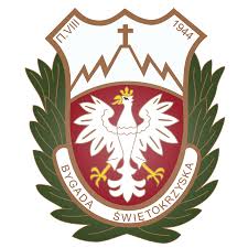 A white eagle with a crown on a red shield, framed by green leaves and a brown border, with Polish text and a cross above mountain peaks.