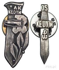 Two metallic badges featuring the letters "KEDYW" and "AK" with stylised knife and resistance symbols, associated with Polish Second World War resistance.